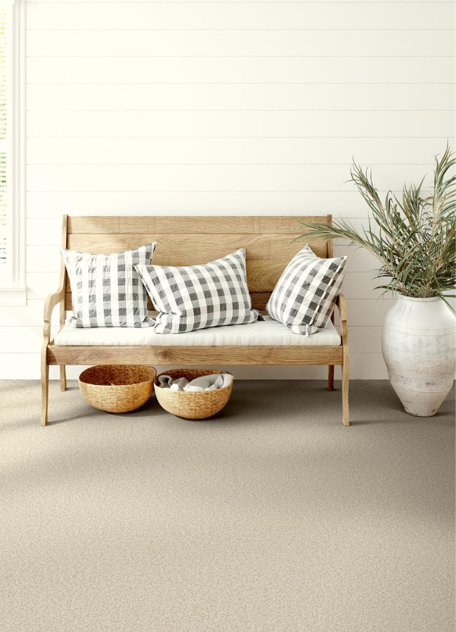 beige carpets in a entryway with a bench